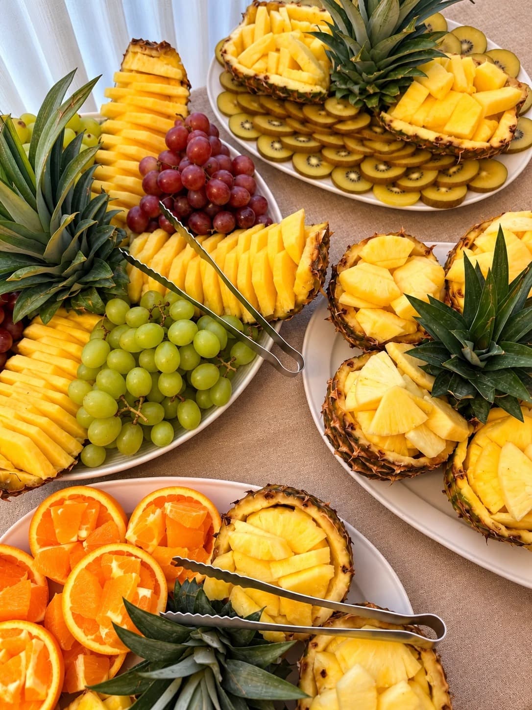 Plateaux de fruits frais : ananas, raisin, kiwi et orange